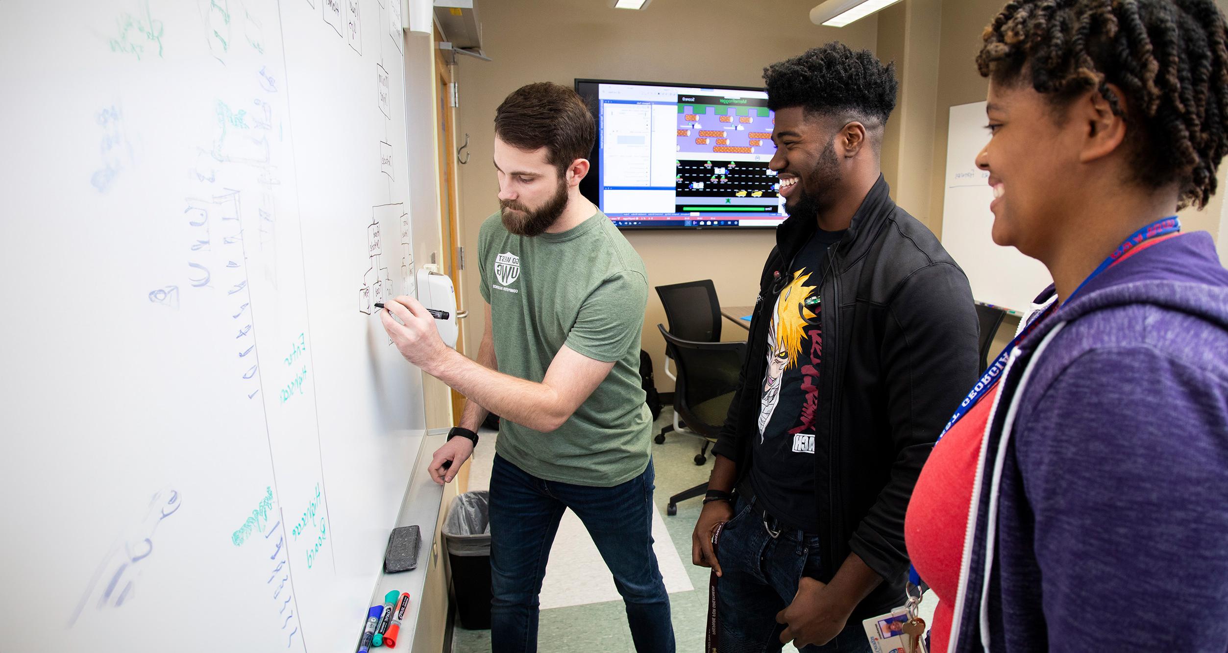 students writing on dry-erase board